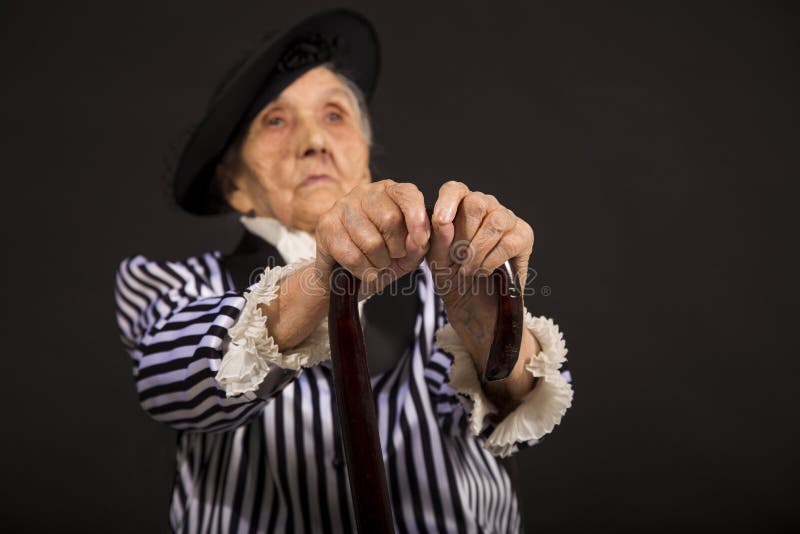Παλαιό grandma σε ένα άσπρος-μαύρο ριγωτό σακάκι στοκ εικόνες